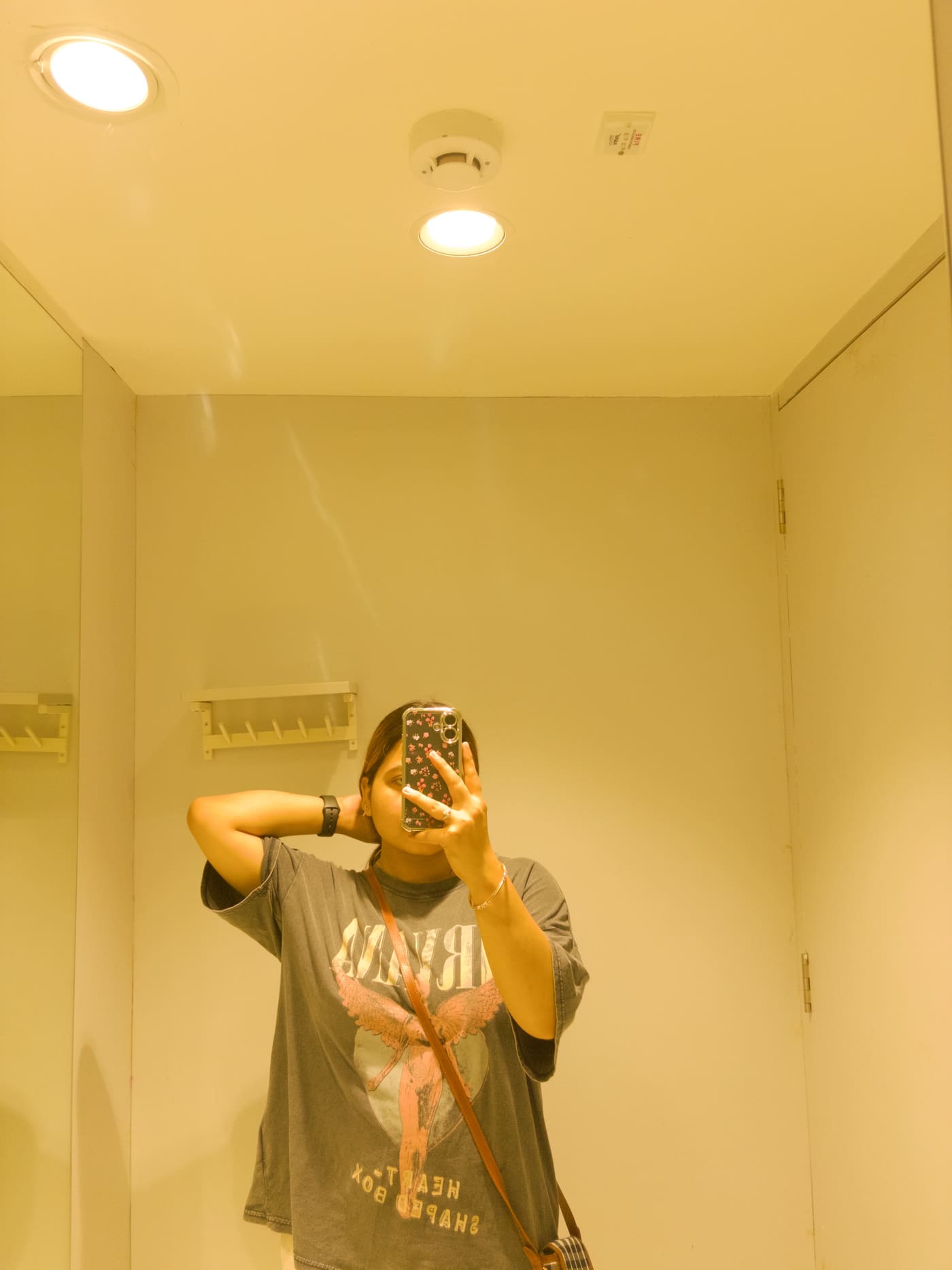 Soumya Singh in an oversized graphic tee, photographed in warm tungsten light